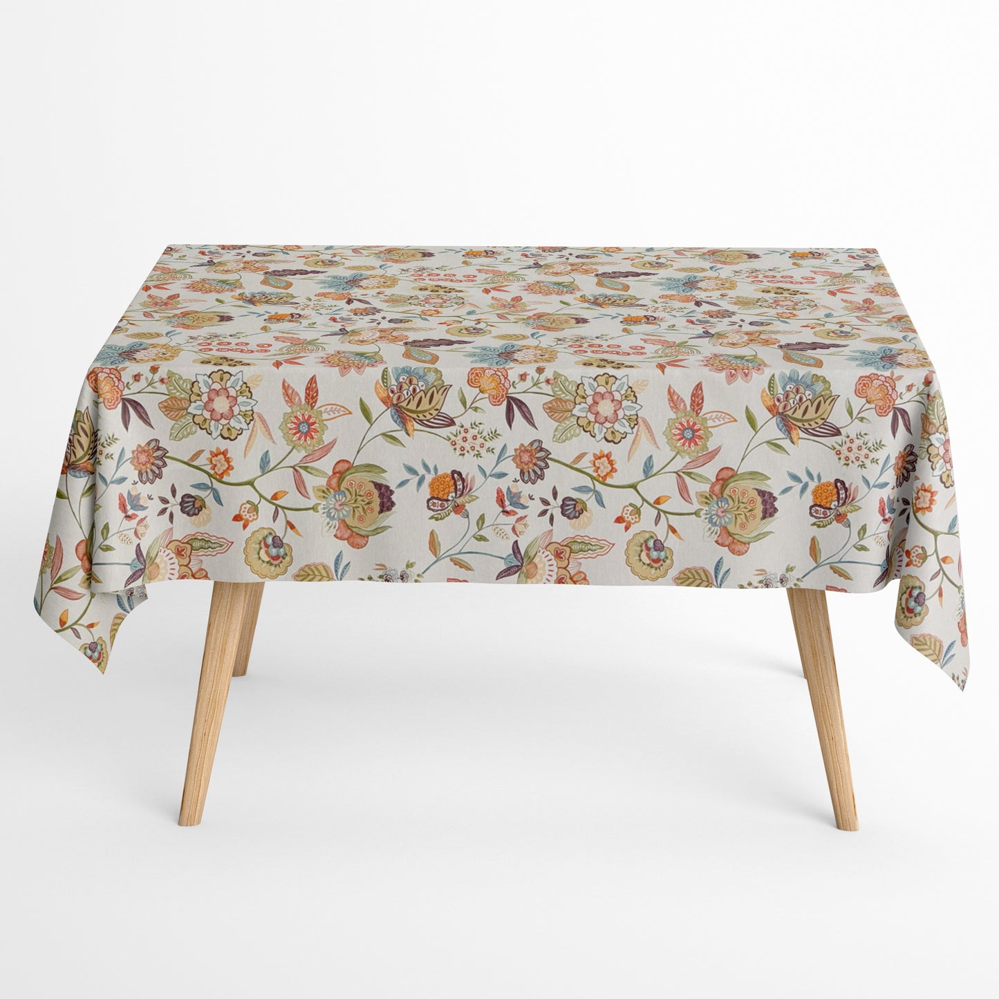 Die Jacquard Tischdecke aus beschichteter Baumwolle zeigt ein detailreiches, boho-inspiriertes Blumenmuster mit verspielten Blüten, Blättern und Ornamenten in warmen Naturtönen wie Beige, Grün, Rost und Blau.