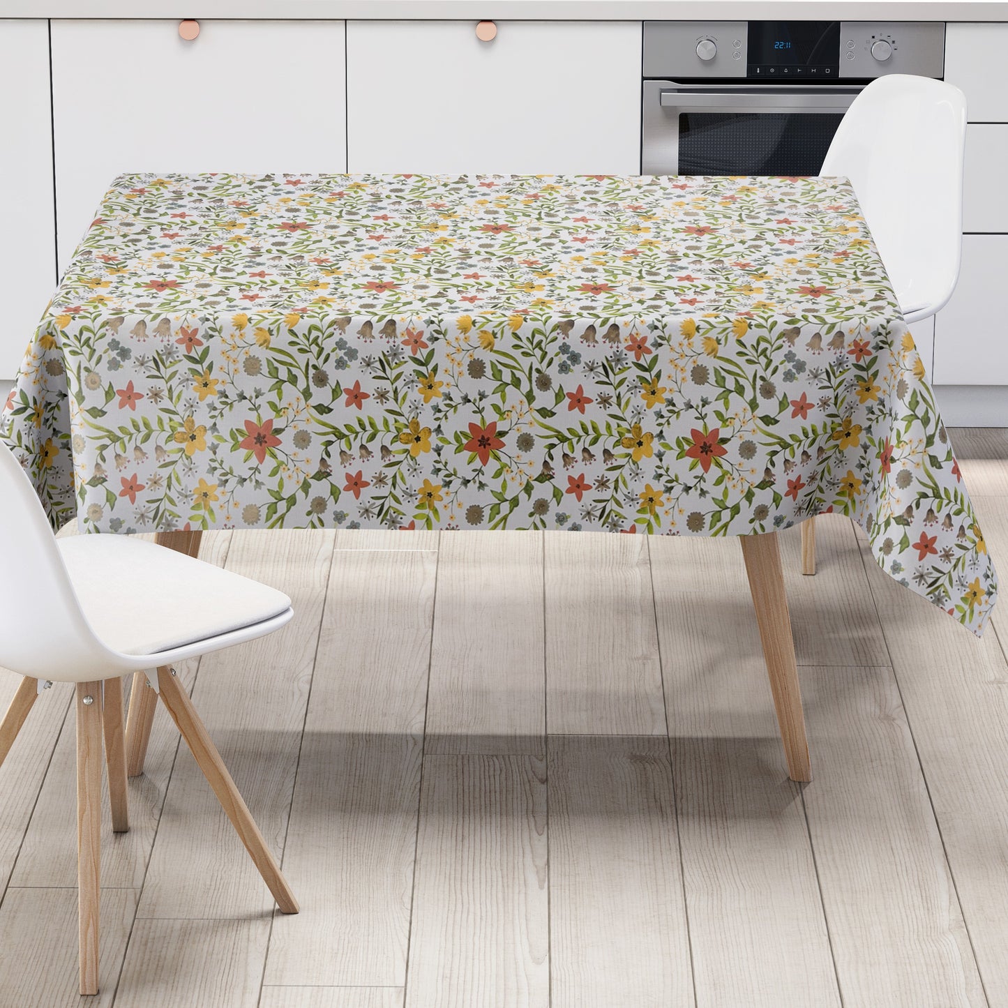 Weiße Wachstuch-Tischdecke mit zartem Blumenwiesen-Muster in Gelb, Apricot, Creme und Grau sowie grünen Blättern und Ranken in natürlicher Aquarell-Optik.