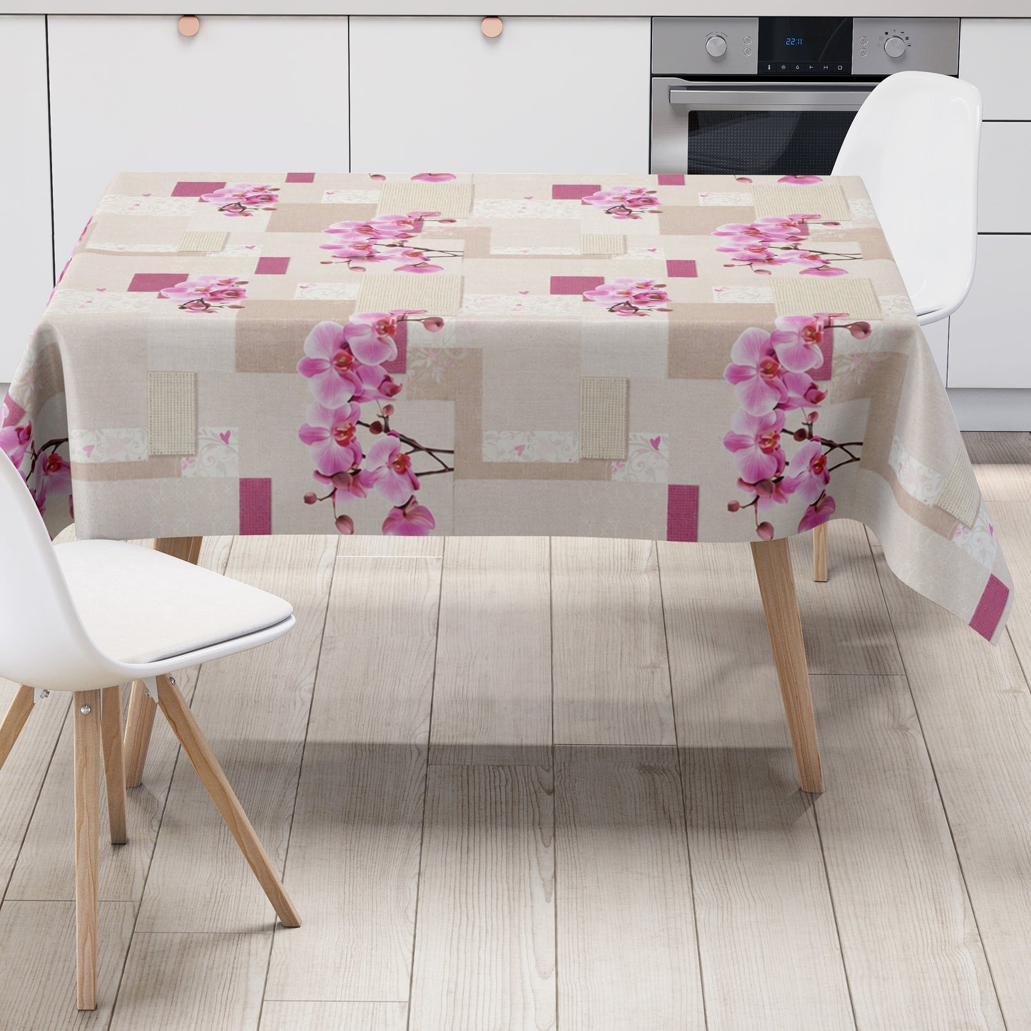 Rechteckiges Wachstuch mit hellem Beige- und Cremeton als Hintergrund, dekoriert mit großen rosa Orchideenblüten, pinkfarbenen Akzenten und einem modernen Patchwork-Muster aus Quadraten, Rechtecken und dezenten floralen Ornamenten. Die Tischdecke wirkt freundlich, elegant und romantisch.