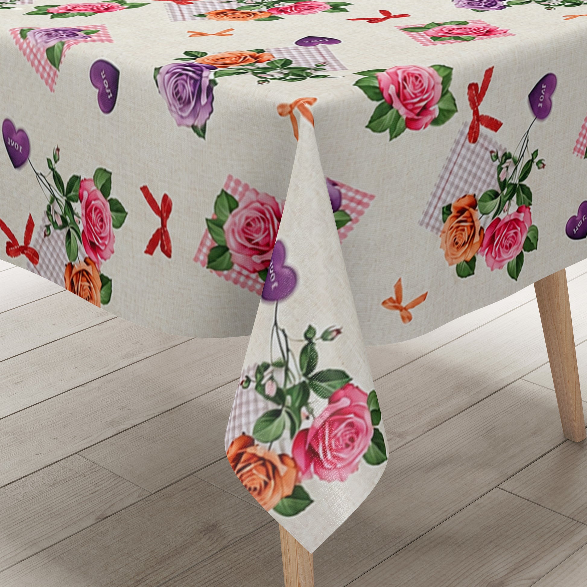 Rechteckige Wachstuch-Tischdecke mit romantischem Blumenmuster auf cremefarbenem Hintergrund. Rosa, lilafarbene und apricotfarbene Rosen wechseln sich mit grünen Blättern, karierten rosa Elementen, kleinen Schleifen und lilafarbenen Herzen mit „Love“-Aufschrift ab. Die Tischdecke fällt dekorativ über die Tischkanten und vermittelt einen verspielten, floralen Landhausstil.