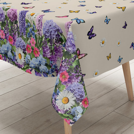 Wachstuch-Tischdecke mit cremefarbenem Hintergrund, dekoriert mit bunten Schmetterlingen und weißen Margeriten. Entlang der Ränder verläuft eine üppige Blumenbordüre aus Lavendel, Hortensien und weiteren Blüten in Violett-, Blau-, Rosa- und Weißtönen. Das frühlingshafte Design erinnert an eine blühende Gartenwiese und sorgt für eine freundliche, sommerliche Atmosphäre.