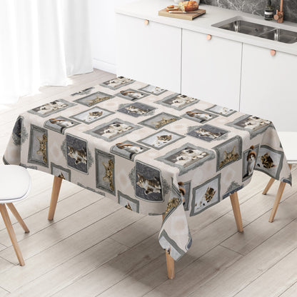 Wachstuch-Tischdecke mit cremefarbenem Hintergrund und dekorativem Katzenmotiv im Vintage-Stil. Verschiedene Katzenporträts in grauen und silbernen Bilderrahmen sind gleichmäßig über die Tischdecke verteilt. Das Design zeigt flauschige Kätzchen und neugierige Katzen mit dezenten Ornamentmustern zwischen den Rahmen.