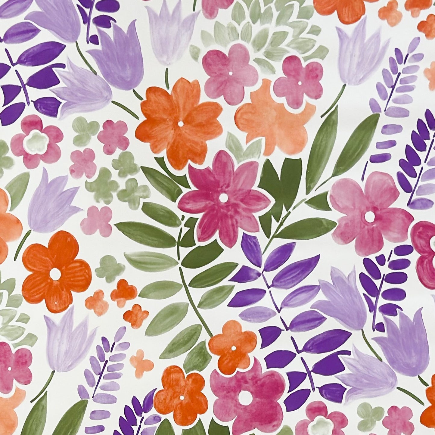 Florale Wachstuch-Tischdecke mit pinken, orangen und violetten Blüten sowie grünen Blättern auf hellem Hintergrund, dichtes und verspieltes Muster für fröhliche und farbenfrohe Tischdekoration