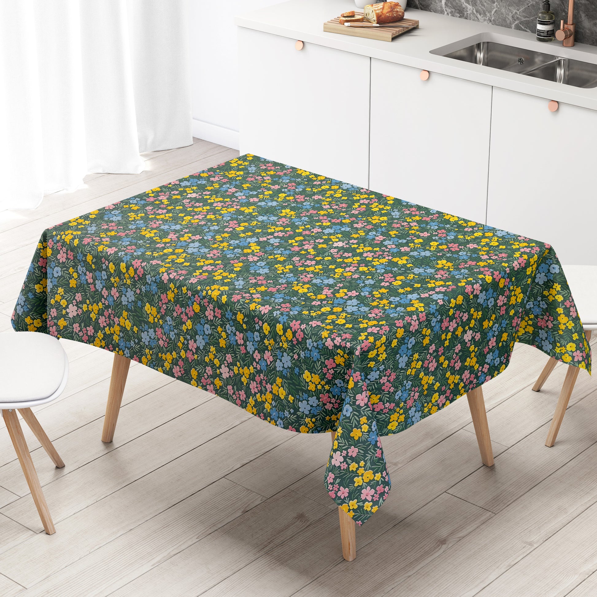 Dunkelgrüne Wachstuch-Tischdecke mit buntem Streublumenmuster aus kleinen gelben, rosa und blauen Blüten sowie feinen grünen Blättern, die über die gesamte Oberfläche verteilt sind.