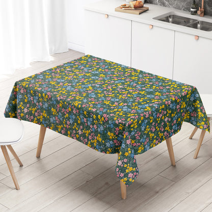 Dunkelgrüne Wachstuch-Tischdecke mit buntem Streublumenmuster aus kleinen gelben, rosa und blauen Blüten sowie feinen grünen Blättern, die über die gesamte Oberfläche verteilt sind.
