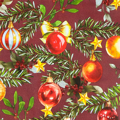 Weihnachtliche Wachstuch-Tischdecke mit bordeauxfarbenem Hintergrund, verziert mit grünen Tannenzweigen, roten, goldenen und grünen Christbaumkugeln sowie kleinen Sternen und Beeren im handgemalten Stil.