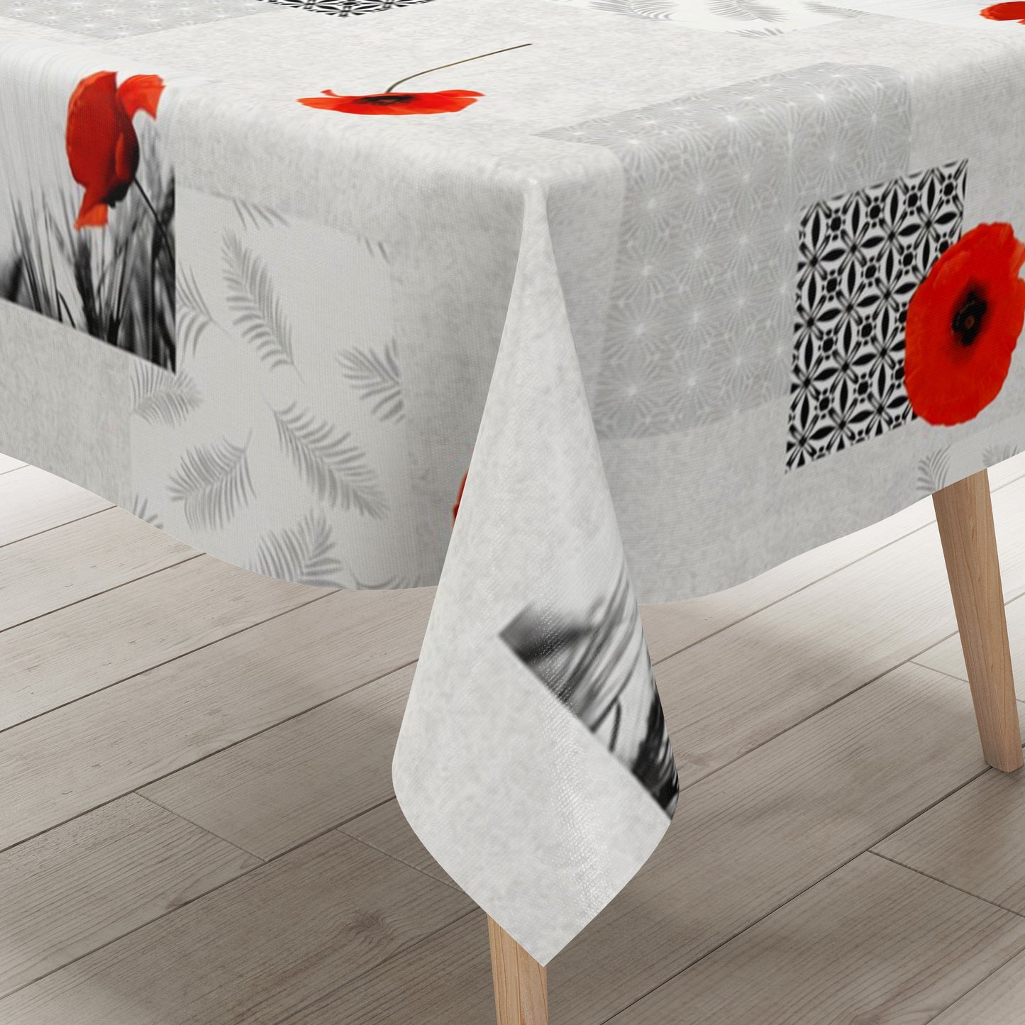 Wachstuch-Tischdecke mit modernem Mohnblumen-Motiv auf hellem Hintergrund. Das Design kombiniert leuchtend rote Mohnblüten mit geometrischen Mustern, filigranen Blattmotiven und dekorativen Schwarz-Weiß-Fotoelementen im Patchwork-Stil. Die wasserabweisende Tischdecke fällt gleichmäßig über die Kanten eines rechteckigen Tisches und ist vor weißem Hintergrund freigestellt dargestellt.
