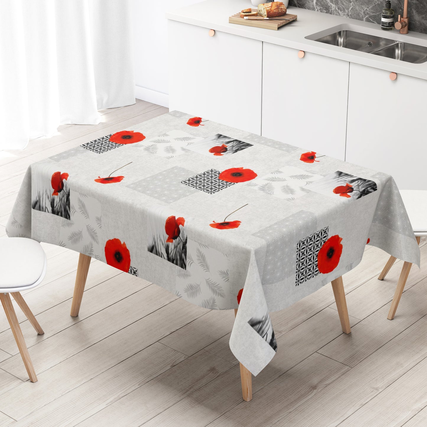 Wachstuch-Tischdecke mit modernem Mohnblumen-Motiv auf hellem Hintergrund. Das Design kombiniert leuchtend rote Mohnblüten mit geometrischen Mustern, filigranen Blattmotiven und dekorativen Schwarz-Weiß-Fotoelementen im Patchwork-Stil. Die wasserabweisende Tischdecke fällt gleichmäßig über die Kanten eines rechteckigen Tisches und ist vor weißem Hintergrund freigestellt dargestellt.