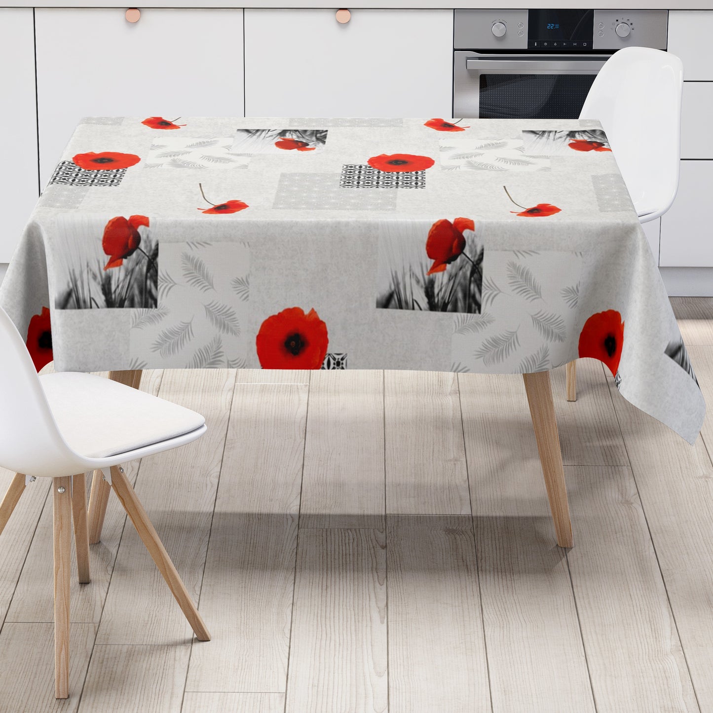 Wachstuch-Tischdecke mit modernem Mohnblumen-Motiv auf hellem Hintergrund. Das Design kombiniert leuchtend rote Mohnblüten mit geometrischen Mustern, filigranen Blattmotiven und dekorativen Schwarz-Weiß-Fotoelementen im Patchwork-Stil. Die wasserabweisende Tischdecke fällt gleichmäßig über die Kanten eines rechteckigen Tisches und ist vor weißem Hintergrund freigestellt dargestellt.