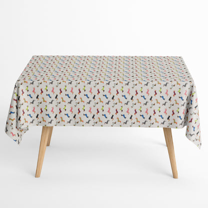 Jacquard Tischdecke aus beschichteter Baumwolle mit kleinem, buntem Dackel-Muster auf hellem Hintergrund, fleckenabweisend und pflegeleicht.