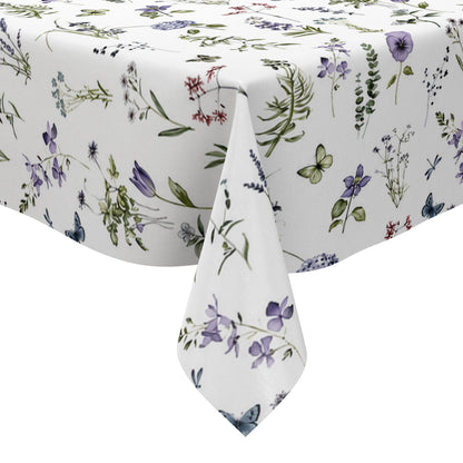 Weiße Wachstuch-Tischdecke mit zartem Wiesenblumen-Muster aus Wildblumen, Gräsern, Schmetterlingen und Libellen in sanften Violett-, Blau- und Grüntönen.