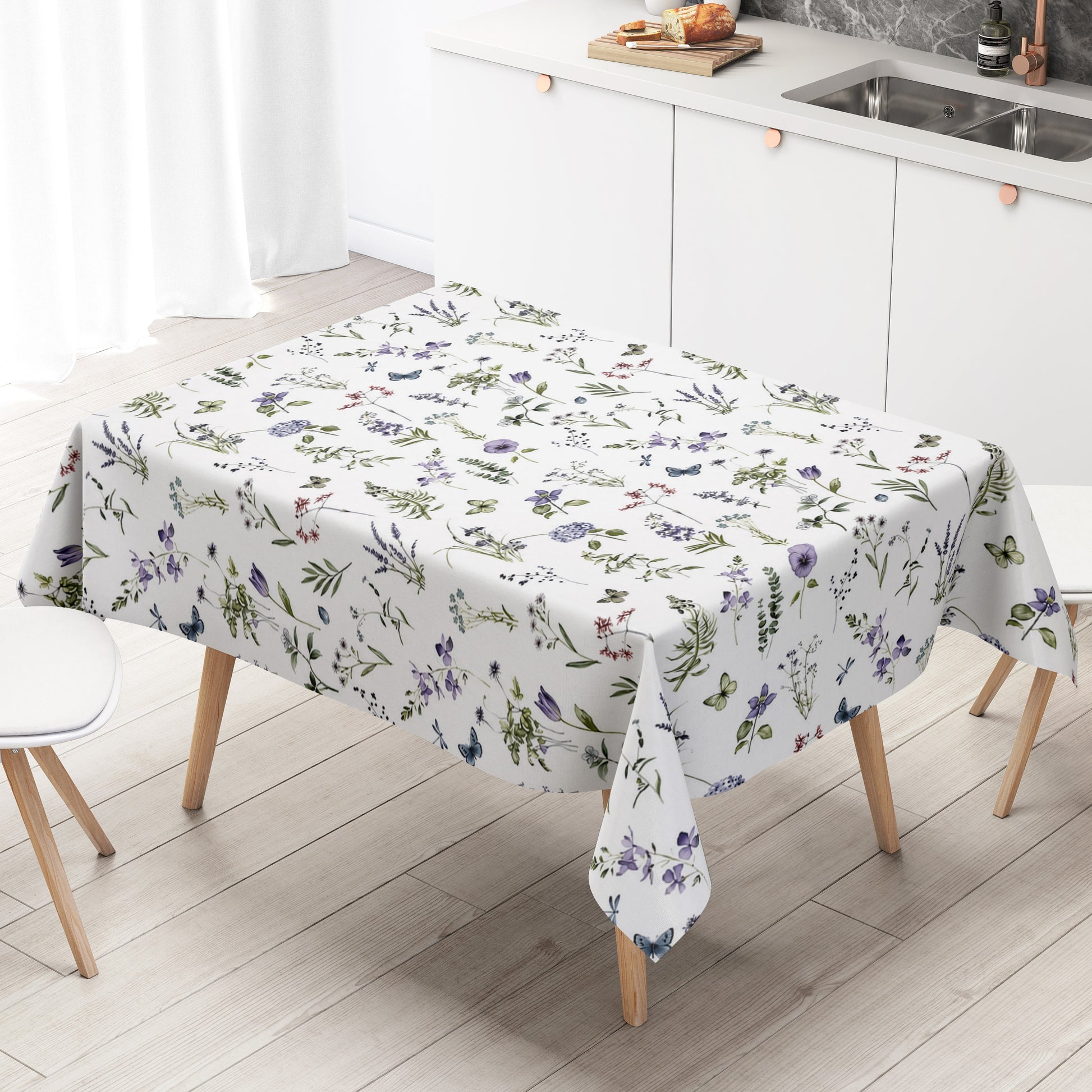 Weiße Wachstuch-Tischdecke mit zartem Wiesenblumen-Muster aus Wildblumen, Gräsern, Schmetterlingen und Libellen in sanften Violett-, Blau- und Grüntönen.