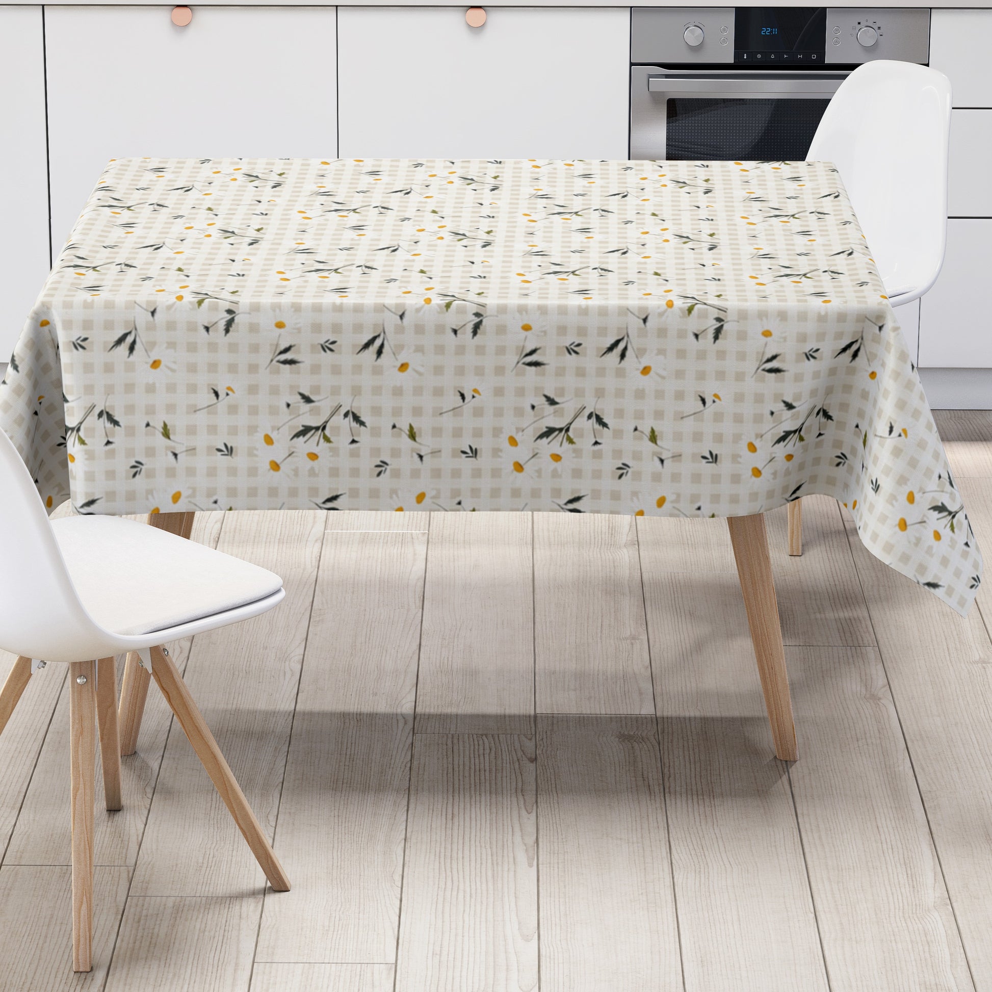 Beige-cremefarbene Wachstuch-Tischdecke mit feinem Karomuster und zarten weißen Margeriten, gelben Blütenmitten sowie filigranen grün-grauen Blättern im harmonischen Landhausdesign.