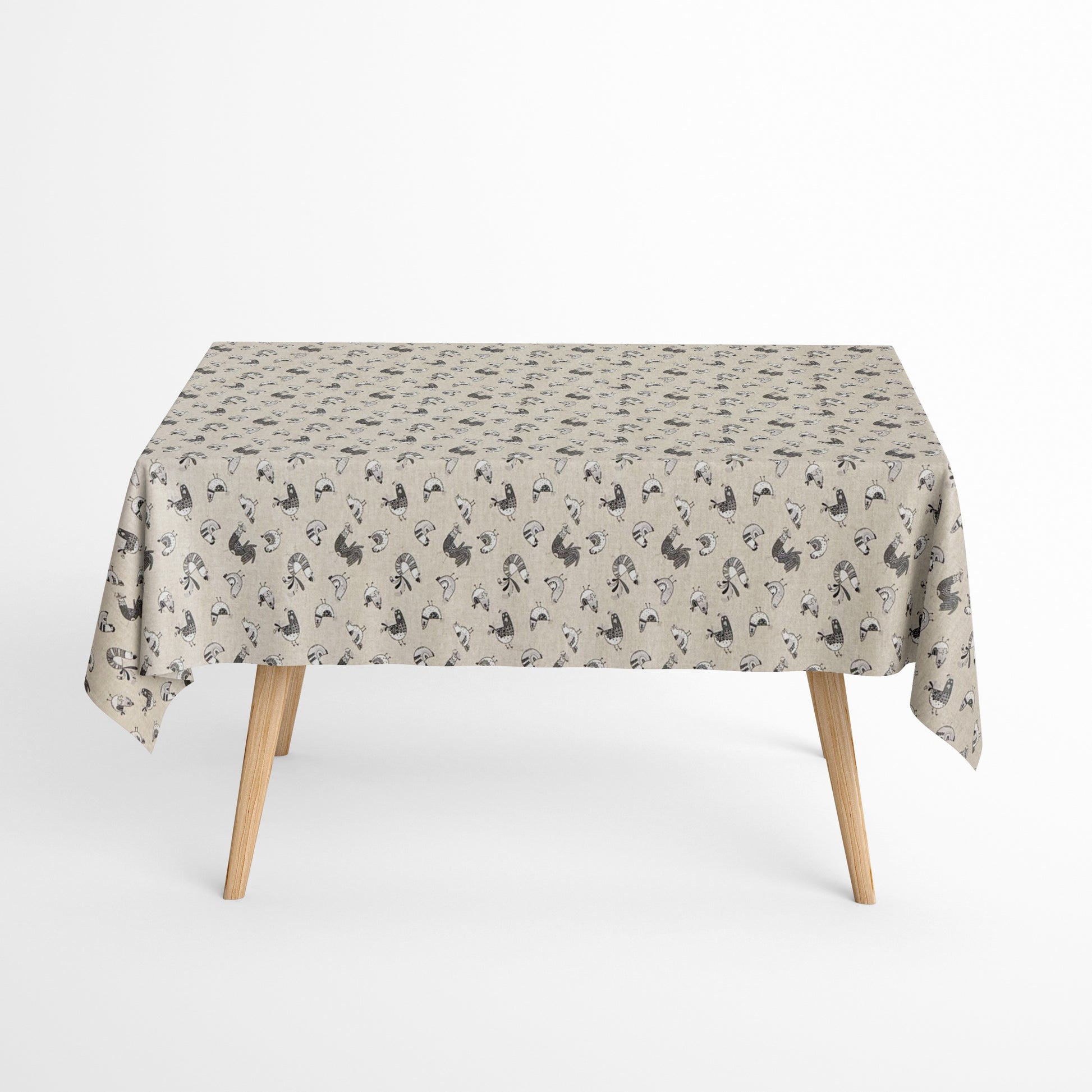 Beschichtete Baumwoll-Tischdecke mit Fleckenschutz im Design FILLOL, naturfarbener Hintergrund mit einem verspielten Allover-Muster aus stilisierten Hühnern und Küken in Schwarz- und Grautönen im skandinavischen Landhausstil.