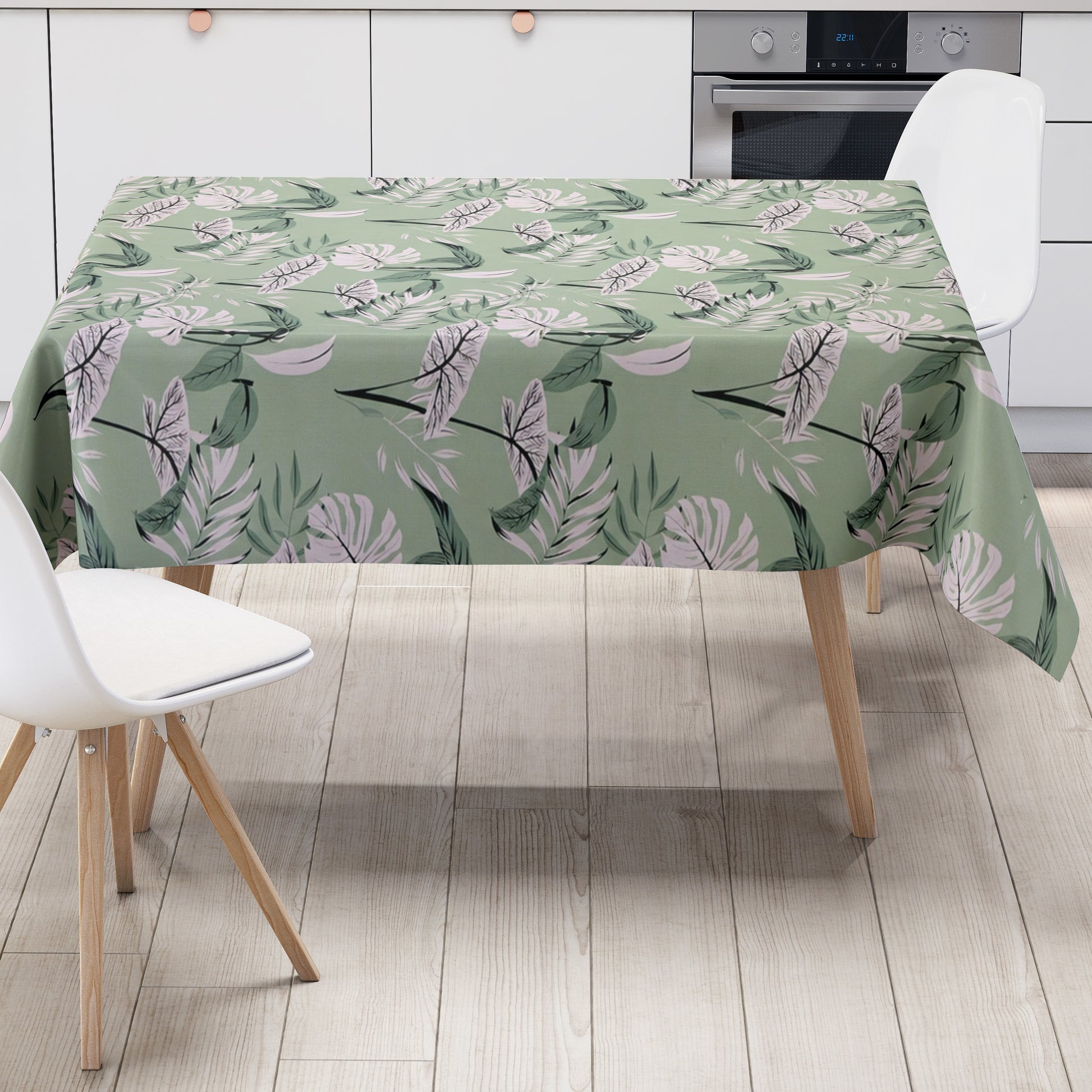 Wachstuch-Tischdecke mit tropischem Blättermuster auf mintgrünem Hintergrund. Weiße, graue und grüne Blätter mit feinen schwarzen Konturen sind gleichmäßig verteilt und erzeugen ein modernes, frisches Naturdesign.