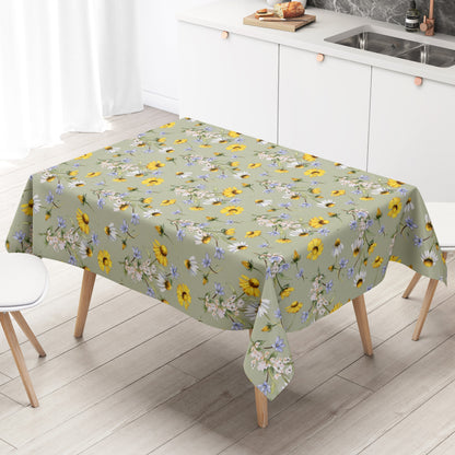 Wachstuch-Tischdecke mit Wiesenblumenmuster auf salbeigrünem Hintergrund. Gelbe Blüten, weiße Margeriten, kleine blaue Blumen und zarte weiße Blütenzweige sind gleichmäßig verteilt und sorgen für eine frische, natürliche Ausstrahlung.