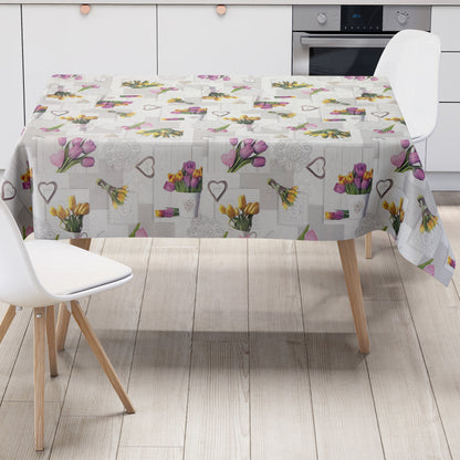 Wachstuch-Tischdecke mit romantischem Patchwork-Dessin in Hellgrau, Weiß und Creme. Das Muster zeigt rosa, violette und gelbe Tulpensträuße, Herzmotive, Spitzenornamente und Holzoptik-Elemente in harmonischer Anordnung. Die floralen Motive verleihen der Tischdecke einen frühlingshaften Landhausstil und schaffen eine freundliche, gemütliche Atmosphäre.