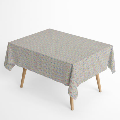 Jacquard-Tischdecke aus beschichteter Baumwolle mit hellem Grund und feinem, buntem Punktmuster in Blau, Rosa, Rot, Gelb, Grün, Orange und Violett.