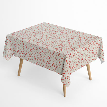 Die Jacquard Tischdecke aus beschichteter Baumwolle zeigt ein feines Streublumenmuster mit kleinen roten Blüten auf hellem, leicht strukturiertem Hintergrund.