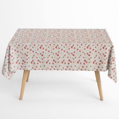 Die Jacquard Tischdecke aus beschichteter Baumwolle zeigt ein feines Streublumenmuster mit kleinen roten Blüten auf hellem, leicht strukturiertem Hintergrund.