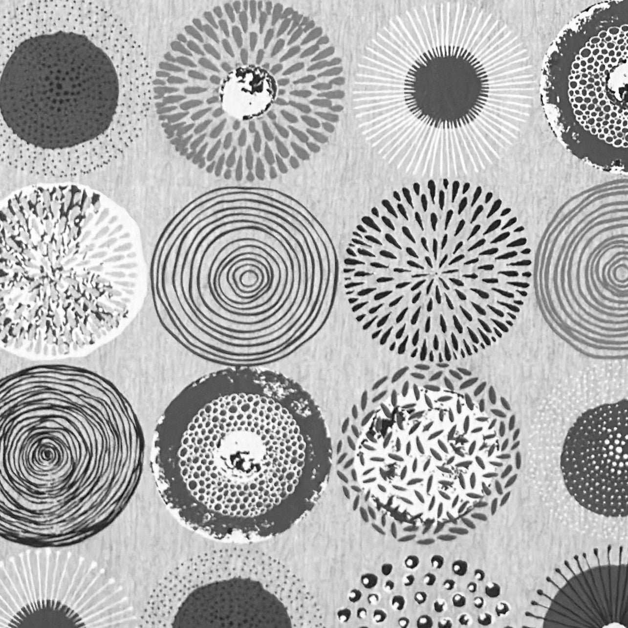 Jacquard-Tischdecke mit grafischem Kreismotiv aus Spiralen, Punkten, Strahlen und floralen Formen in Grau, Weiß und Anthrazit.