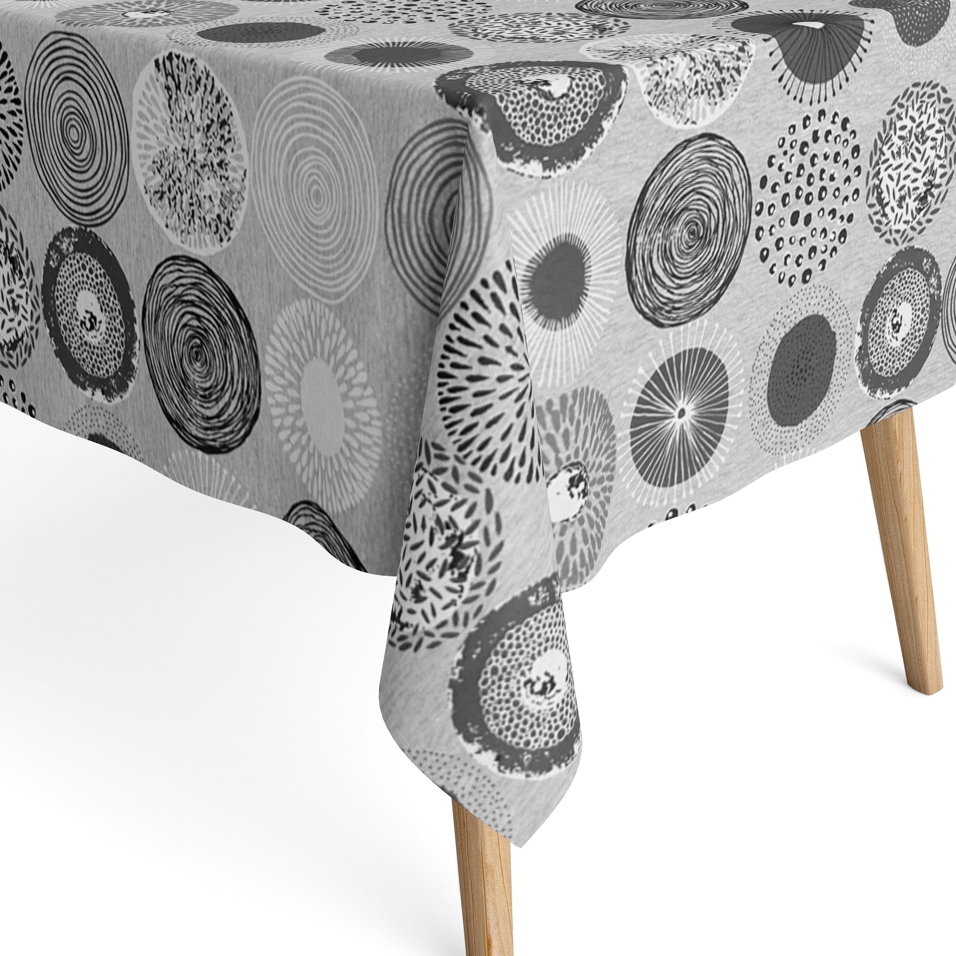 Jacquard-Tischdecke mit grafischem Kreismotiv aus Spiralen, Punkten, Strahlen und floralen Formen in Grau, Weiß und Anthrazit.
