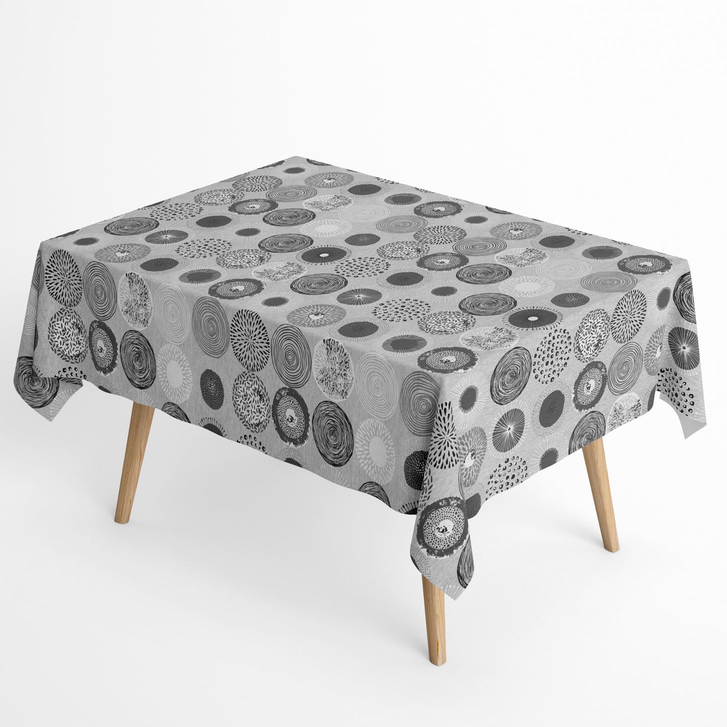 Jacquard-Tischdecke mit grafischem Kreismotiv aus Spiralen, Punkten, Strahlen und floralen Formen in Grau, Weiß und Anthrazit.