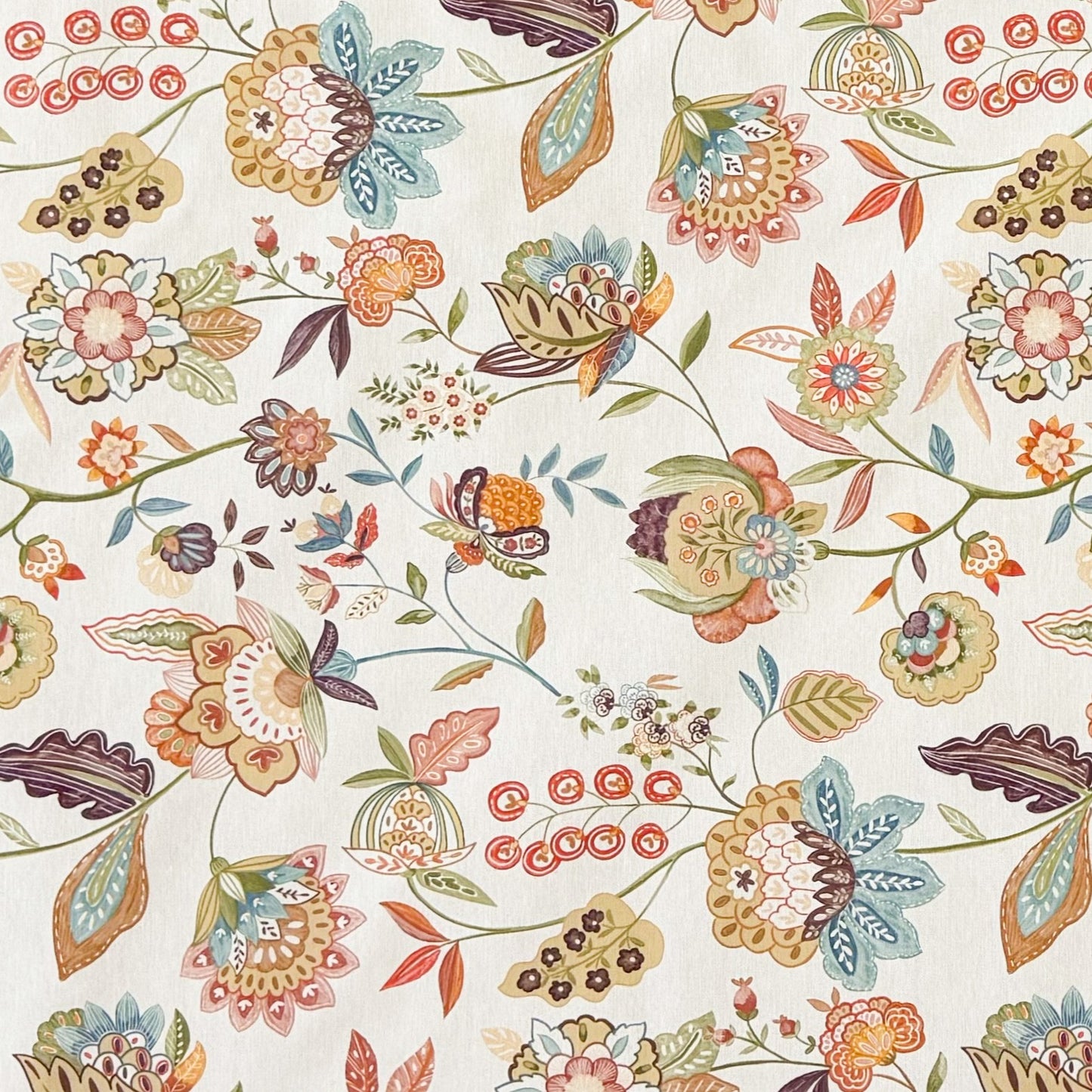 Die Jacquard Tischdecke aus beschichteter Baumwolle zeigt ein detailreiches, boho-inspiriertes Blumenmuster mit verspielten Blüten, Blättern und Ornamenten in warmen Naturtönen wie Beige, Grün, Rost und Blau.