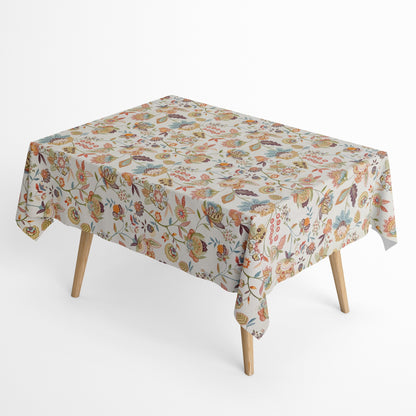 Die Jacquard Tischdecke aus beschichteter Baumwolle zeigt ein detailreiches, boho-inspiriertes Blumenmuster mit verspielten Blüten, Blättern und Ornamenten in warmen Naturtönen wie Beige, Grün, Rost und Blau.