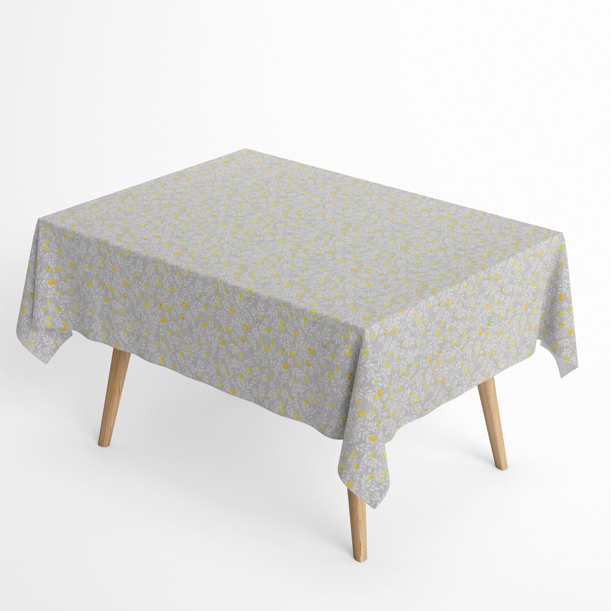 Die Jacquard Tischdecke aus beschichteter Baumwolle zeigt ein feines, dichtes Allover-Muster aus kleinen Zitronen und zarten Blättern in Gelb- und Grautönen.
