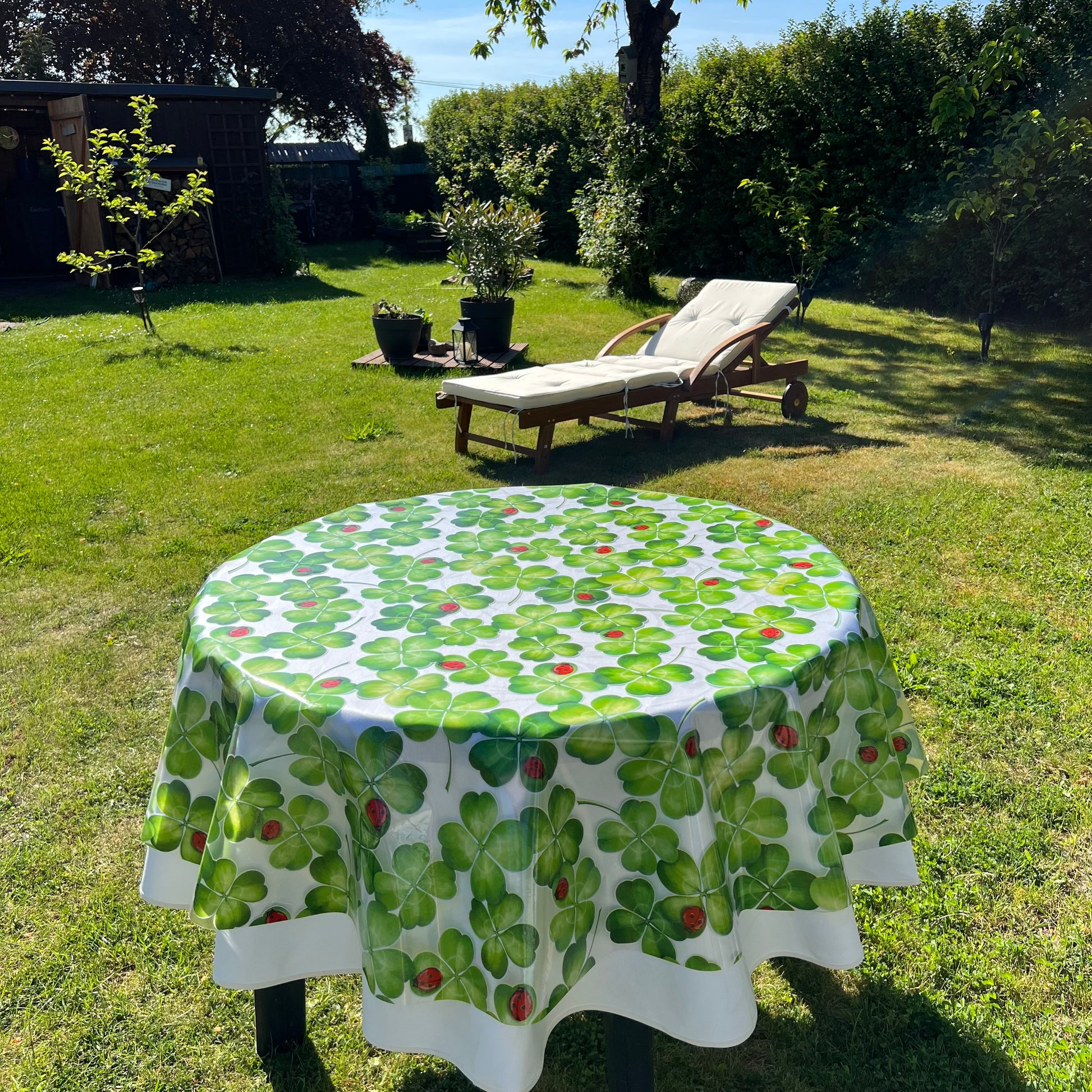 bedruckte Folie mit Klee und Marienkäfer auf einer weißen Stofftischdecke mit floralem Muster fotografiert