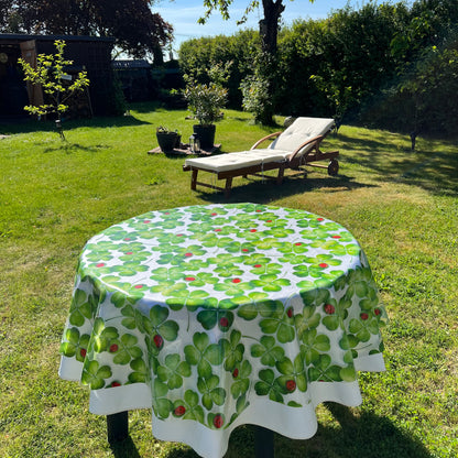 bedruckte Folie mit Klee und Marienkäfer auf einer weißen Stofftischdecke mit floralem Muster fotografiert