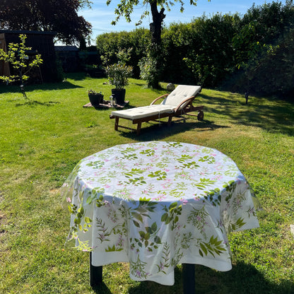 bedruckte Folie mit Kräutern auf einer weißen Stofftischdecke mit floralem Muster fotografiert